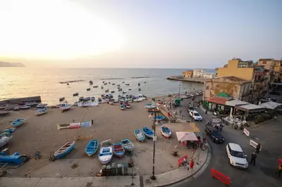 a group of people on a beach near the water at La casa di Jack in Bagheria