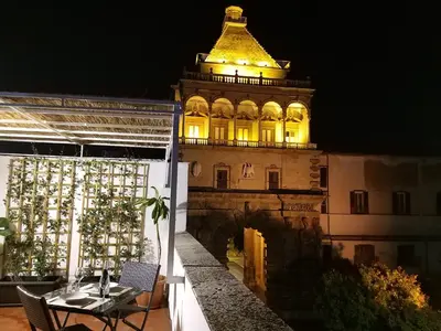a building with a clock tower at night at La Porta dei Mori in Palermo