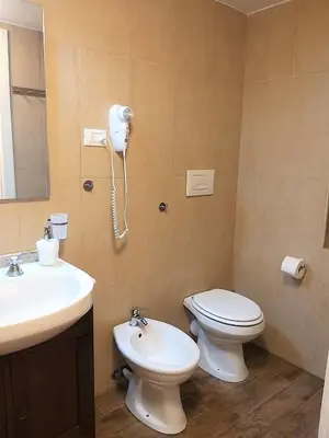 a bathroom with a toilet and a sink and a phone at La Porta dei Mori in Palermo
