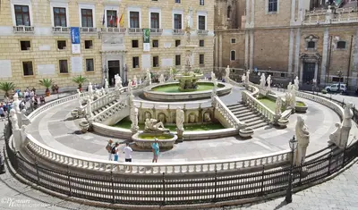 people standing in front of a building with a fountain at La Porta dei Mori in Palermo