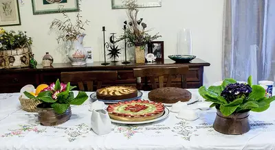 a table with a pizza and flowers on it at Bed And Breakfast Maria in Scopello
