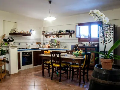 a kitchen with a table and chairs in a room at Bed And Breakfast Maria in Scopello
