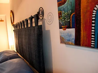 a blanket hanging on a wall next to a painting at Bed And Breakfast Maria in Scopello