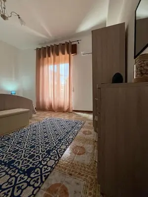 a living room with a bed and a rug on the floor at Casa Vacanza Randazzo in Trappeto