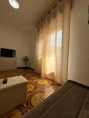 a bedroom with a bed and a tv and a window at Casa Vacanza Randazzo in Trappeto