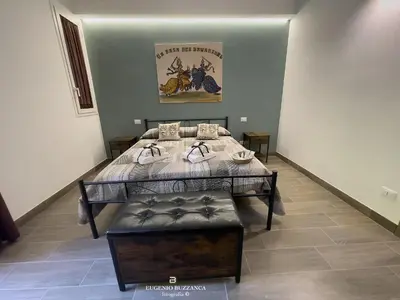 a room with a bed with a table and a bench at La Casa Dei Cavalieri in Caccamo