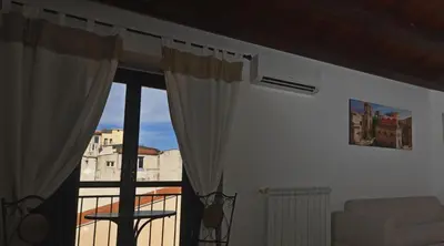 a room with a window with a view of a building at La Casa di Filippo in Palermo
