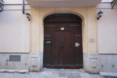 a wooden door in a building with an arch at La Casa di Filippo in Palermo