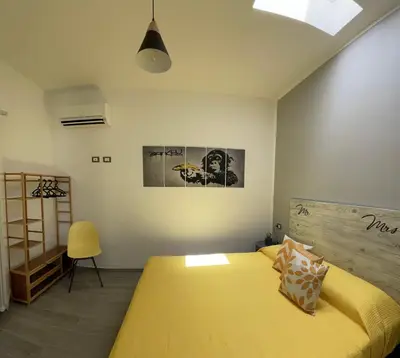 a bedroom with a large yellow bed in a room at La Terrazza del Capo in San Vito lo Capo
