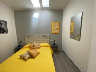 a bedroom with a yellow bed with two pillows on it at La Terrazza del Capo in San Vito lo Capo