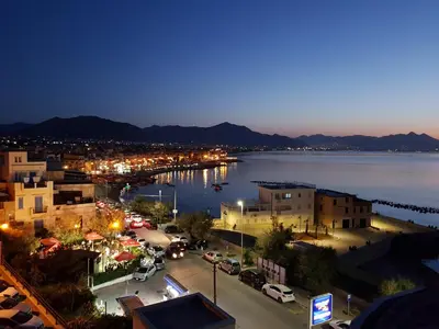 a view of a city with a harbor at night at Calipso in Bagheria