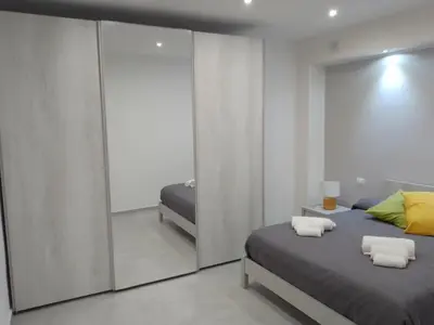 a bedroom with a bed and a mirror at Holiday House Monalisa in Terrasini