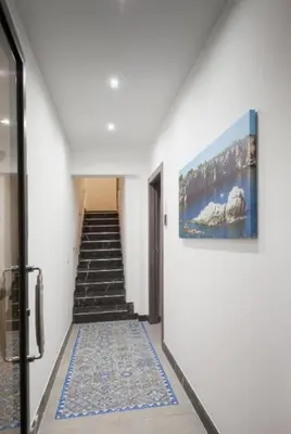 a hallway with stairs and a painting on the wall at Holiday House Monalisa in Terrasini