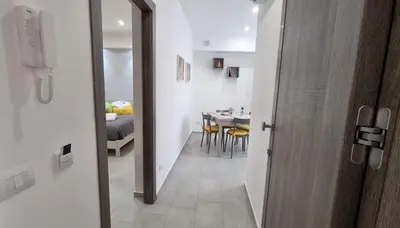 a hallway leading to a dining room with a table at Holiday House Monalisa in Terrasini