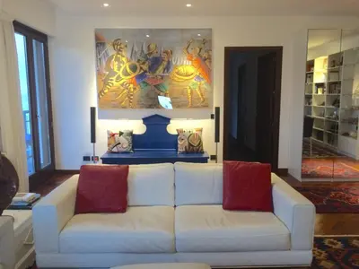 a living room with a white couch and a painting at Mondello Luxury Apartment on the Beach in Mondello