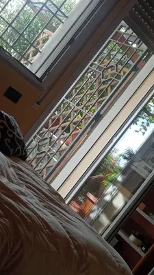 a bedroom with two large windows and a balcony at Nido del falco in Mondello