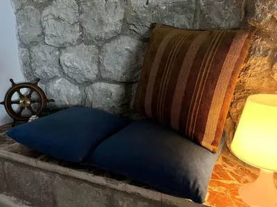 a blue pillow sitting next to a stone wall at Nido del falco in Mondello