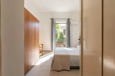 a bedroom with a bed and a door to a window at I Mori-holiday apartment in Palermo