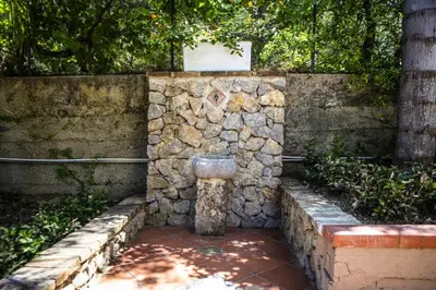 a stone wall with a water fountain in it at La Murgiulina in Carini
