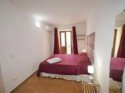 a bedroom with a red bed in a room at Vecchio Cortile Home Holidays in Palermo