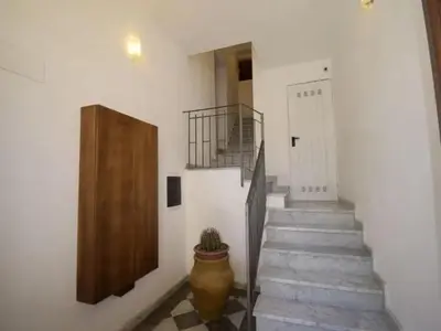 a hallway with stairs and a door and a potted plant at Vecchio Cortile Home Holidays in Palermo