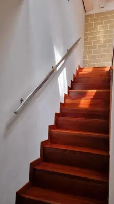 a stairway with wooden steps and a brick wall at 2 Sicilie Rooms and Suite in Centro in Palermo