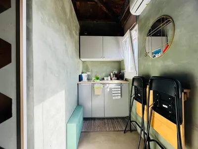 a small kitchen with white cabinets and a blue bench at A Nicuzza in Palermo
