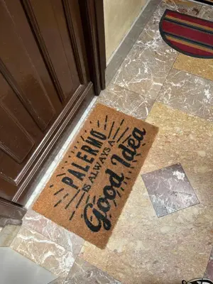 a welcome mat on the floor in front of a door at A Nicuzza in Palermo