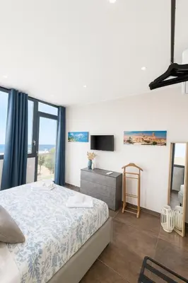 a bedroom with a bed and a tv and windows at Marine Case Vacanze in Palermo
