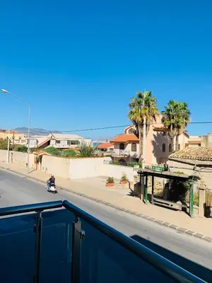 a scooter driving down a street with palm trees at Marine Case Vacanze in Palermo