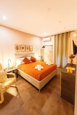 a bedroom with a large orange bed and a chair at Marine Case Vacanze in Palermo