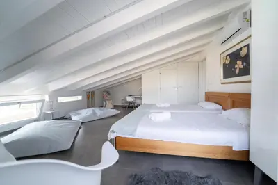 a bedroom with two beds in a attic at Villa Majestatis in Scopello