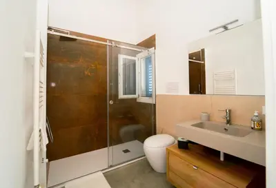 a bathroom with a shower and a toilet and a sink at Villa Majestatis in Scopello