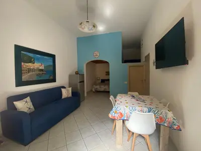 a living room with a blue couch and a table at La casetta del sole in Castellammare del Golfo