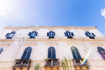a white building with windows and balconies on it at La Dimora del Conte, immersa nel verde in centro città in Palermo