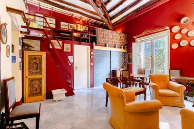 a living room with red walls and orange chairs at La Dimora del Conte, immersa nel verde in centro città in Palermo