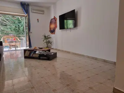 a living room with a tv and a tiled floor at Lo Scorcio sul Mare by Holiday World in Isola delle Femmine