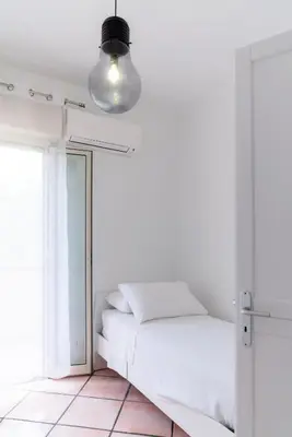 a white bedroom with a bed and a mirror at MONDELLO COTTAGE in Mondello