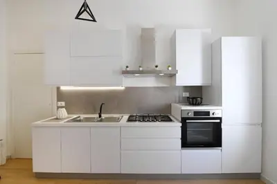 a white kitchen with a sink and a stove at A CANTUNERA in Balestrate