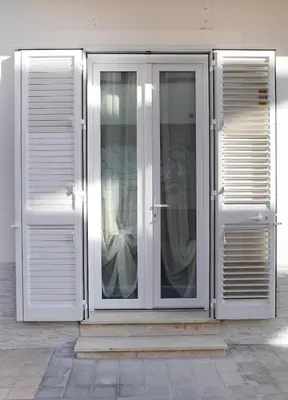 a white pivot door on the side of a building at A CANTUNERA in Balestrate