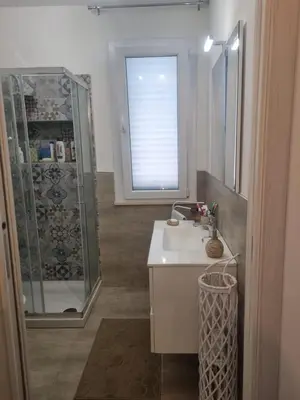 a bathroom with a sink and a shower with a window at Magnolia in Campofelice di Roccella