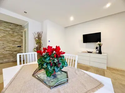 a vase with red flowers on a table in a room at Rosa di Mare in Capaci