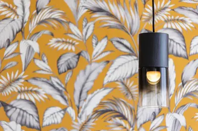 a black lamp hanging from a wall with a floral wallpaper at Le Gemme di Cavour Luxury Rooms in Palermo