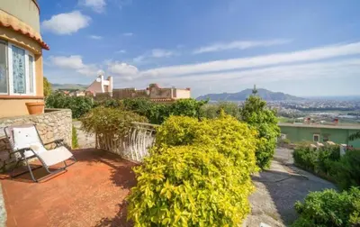 a balcony of a house with a chair and flowers at La Conca D'Oro in Palermo