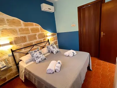 a bedroom with a table with towels on it at Celeste Rooms in San Vito lo Capo