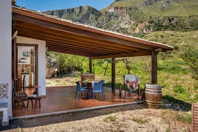 a wooden deck with a table and chairs on a house at Villa Elena 2 Km from the Natural Reserve of Zingaro in Scopello