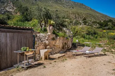 a yard with two chairs and a table and a fence at Villa Elena 2 Km from the Natural Reserve of Zingaro in Scopello
