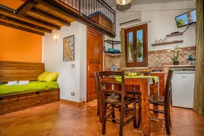 a kitchen and dining room with a table and a bed at Villa Elena 2 Km from the Natural Reserve of Zingaro in Scopello