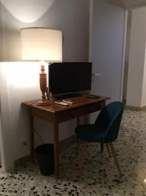 a desk with a computer monitor and a blue chair at Casa Marele in Palermo