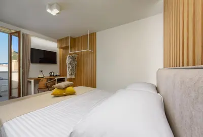 a bedroom with a white bed with a yellow duck on it at IL MARE DENTRO SUITES in San Vito lo Capo